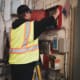 A man in a safety vest working on an electrical panel