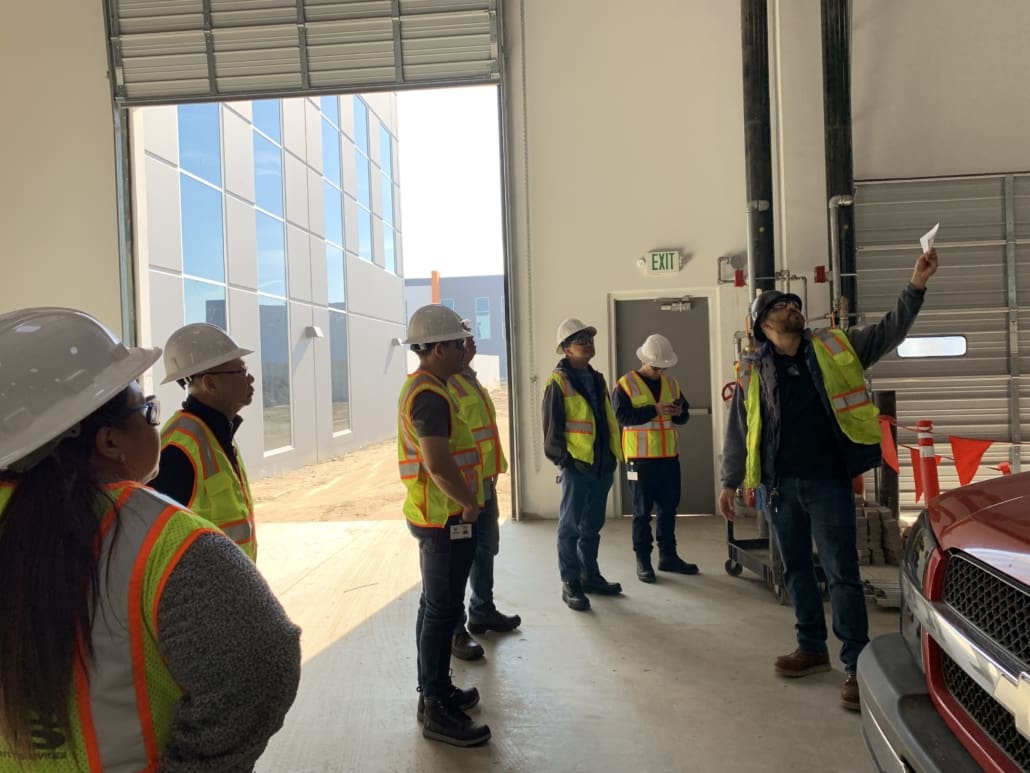 A group of people in safety vests and hard hats