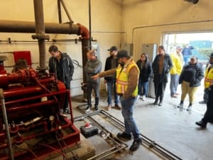 A group of people standing around a machine