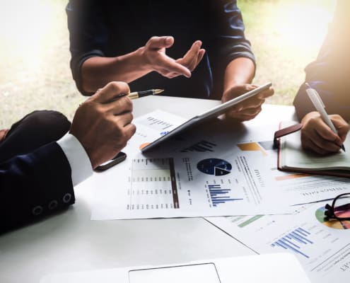 Business people using pen,tablet,notebook are planning a marketing plan to improve the quality of their sales in the future.