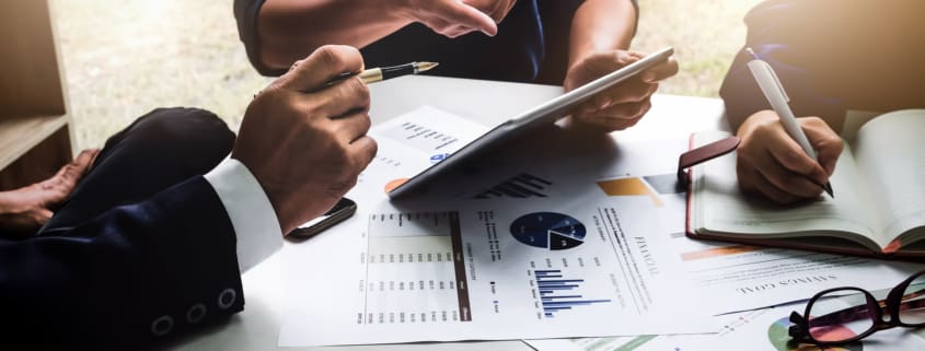 Business people using pen,tablet,notebook are planning a marketing plan to improve the quality of their sales in the future.